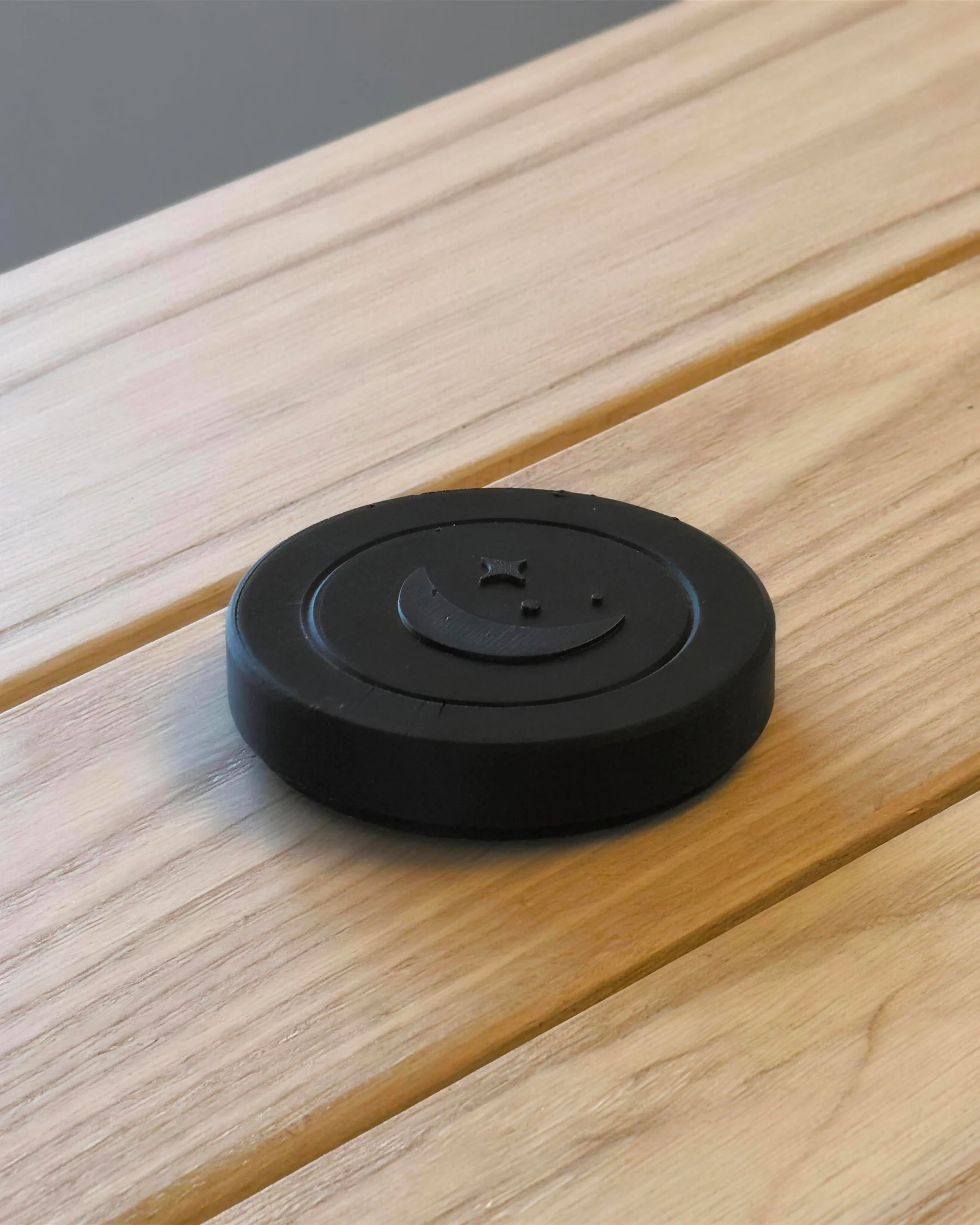 The Sleepslab on a wooden table, with the moon and three stars in relief on top